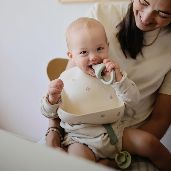 mushie Silicone Baby Bib | Adjustable Fit Waterproof Bibs (Pretzel)
